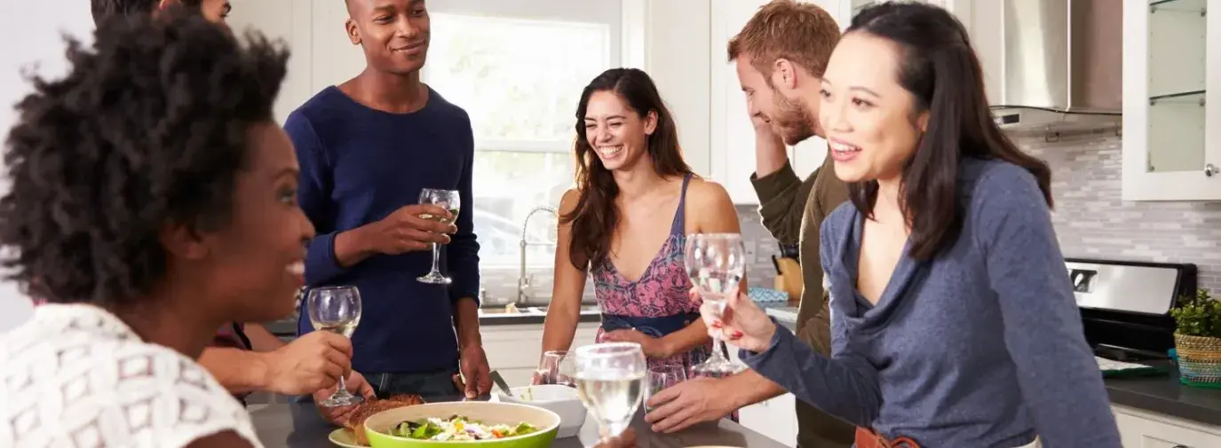 Image: gathering of people with around around kitchen island. Title: Throwing a Fair Trade Party